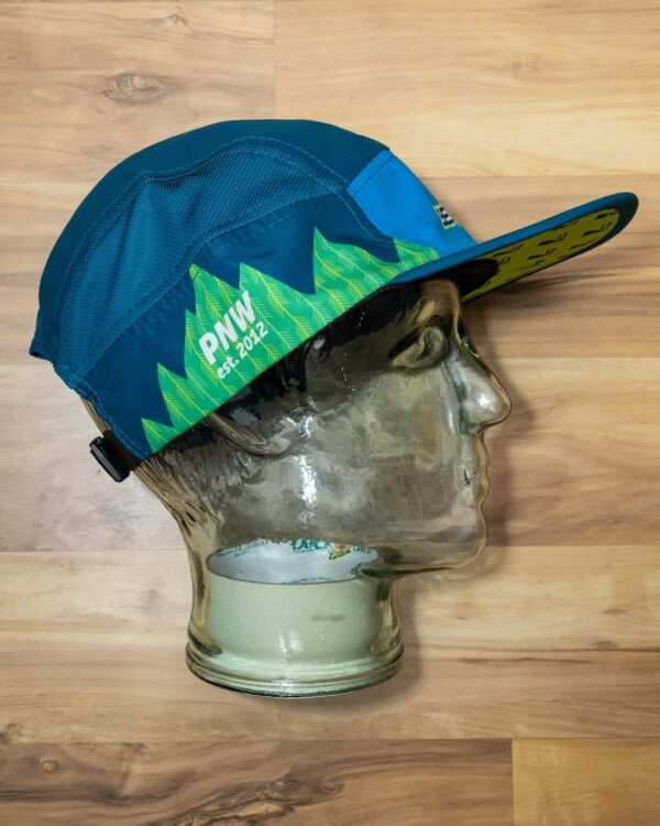 Side view of the blue and green Seven Hills Running Shop sublimated performance running cap from Boco Gear.