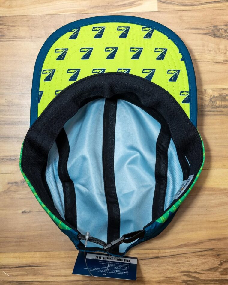 Underside of a Seven Hills Running Shop running hat showing the under-brim with a pattern of Team7Hills logo 7s.
